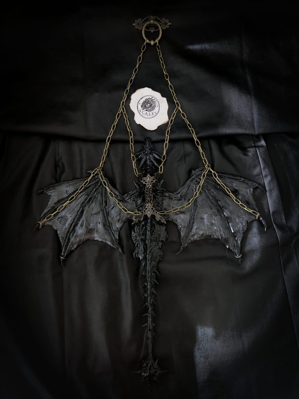     Sculpture suspendue de Tairn avec ailes déployées et chaînes métalliques – Scales