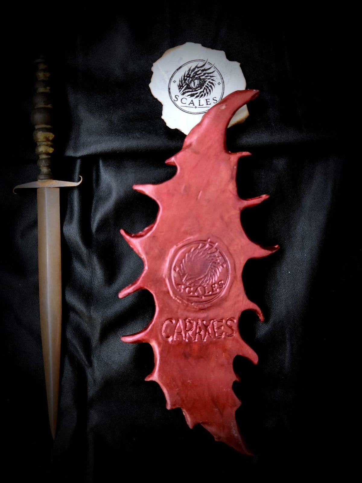Détail des reliefs et nuances rouges de la pièce unique Caraxes
