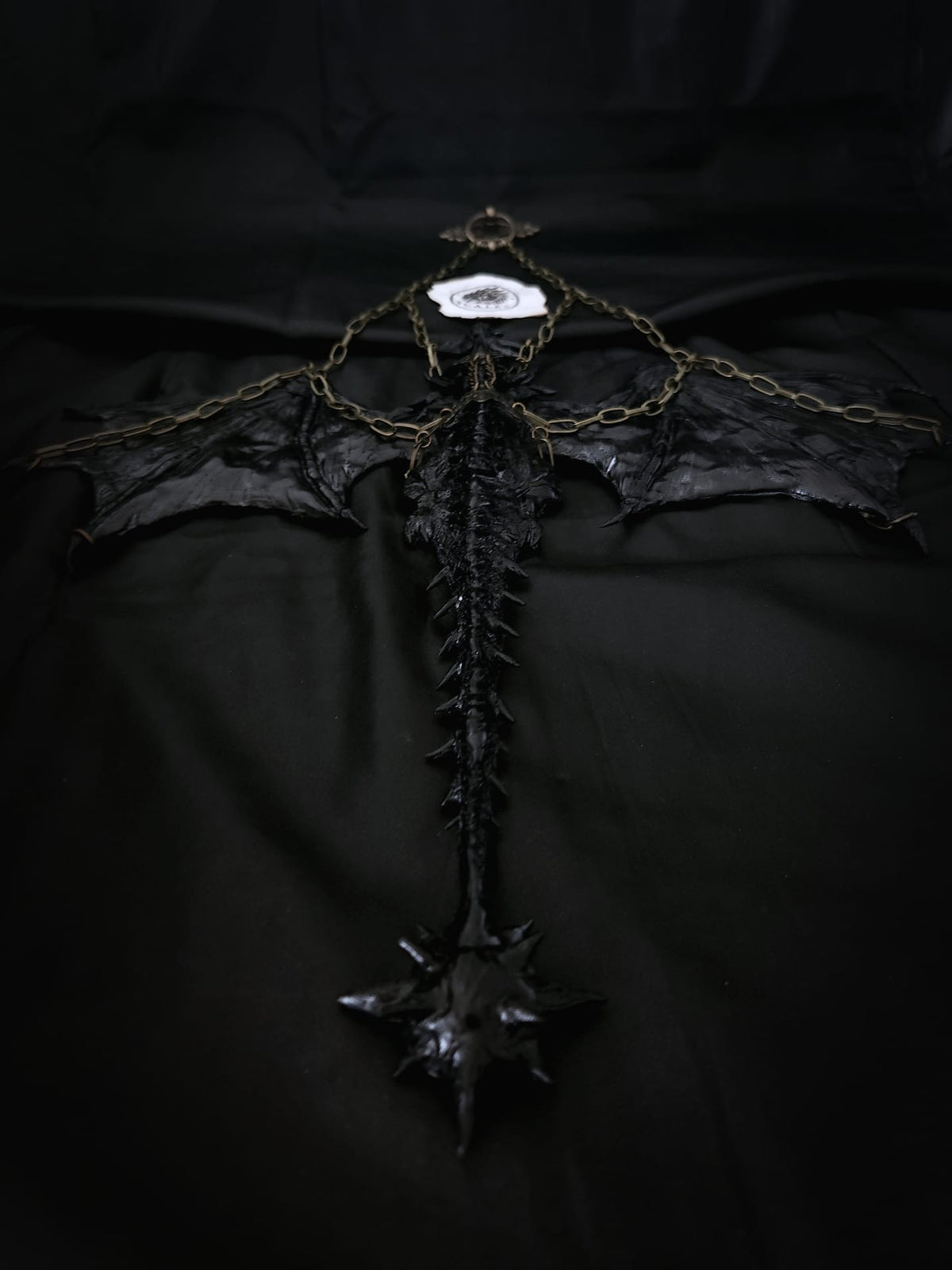     Sculpture suspendue de Tairn avec ailes déployées et chaînes métalliques – Scales